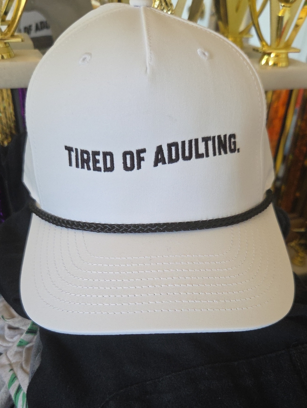 White Trucker Hat with "TIRED OF ADULTING." Embroidery